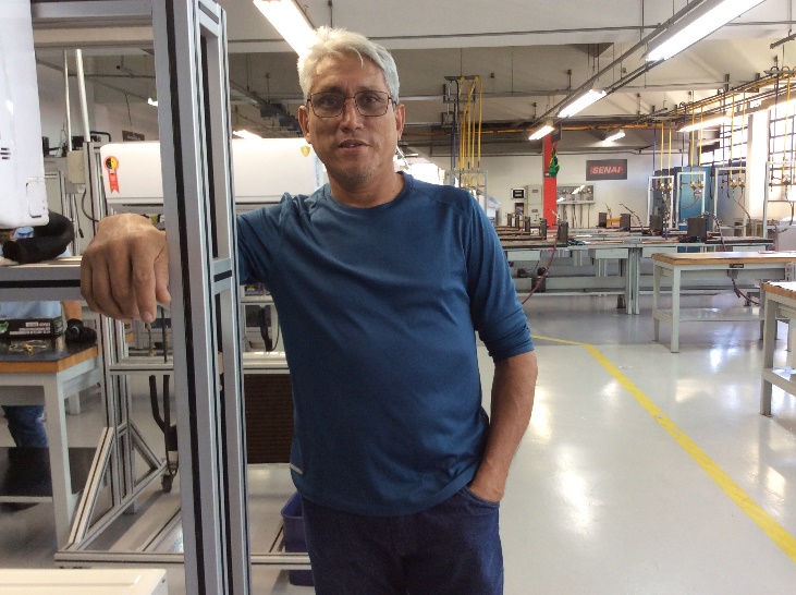 Homem em cozinha industrial Descrição gerada automaticamente com confiança média