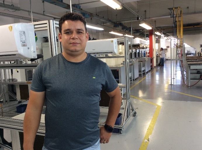 Homem em pé em cozinha industrial Descrição gerada automaticamente